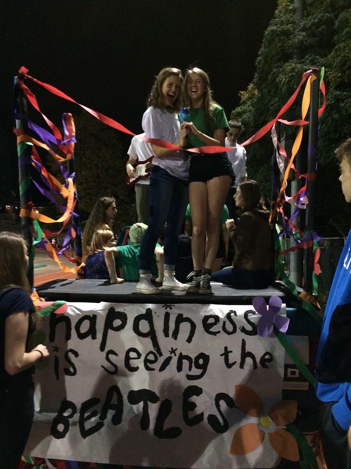 Junior homecoming representatives Tori Tefft (left) and Kayla Nichols (right) get ready to ride out on their homecoming float