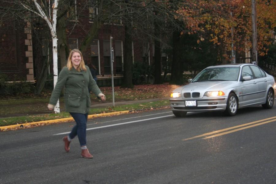 A student crosses the street at the location of the proposed sidewalk
