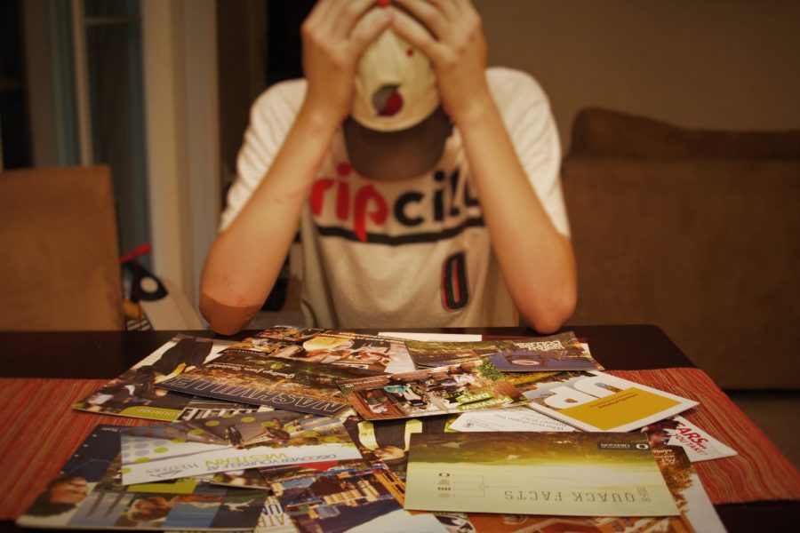 Junior Jackson Latimer stares at a pile of college information packets.