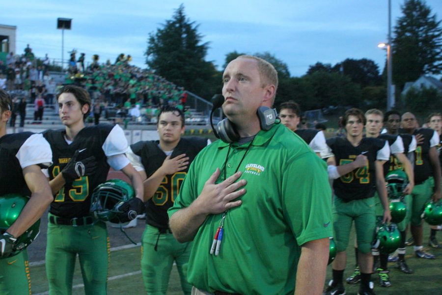 Coach Eric Frasier stands beside his team during the national anthem.