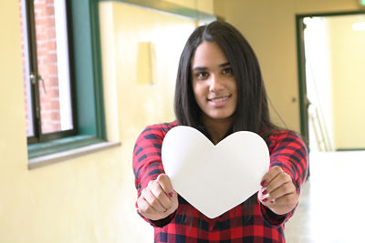Senior Adriana Hernandez holds out a heart. 