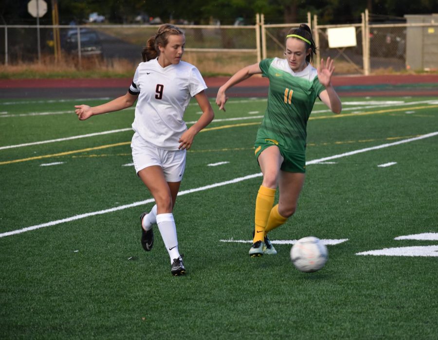 Grace Buchanan, junior, dribbles past defender Katrianne Sinn of Silverton. The Warriors defeated the Foxes 3-0 on Sept. 11 to improve their record to 3-1. 