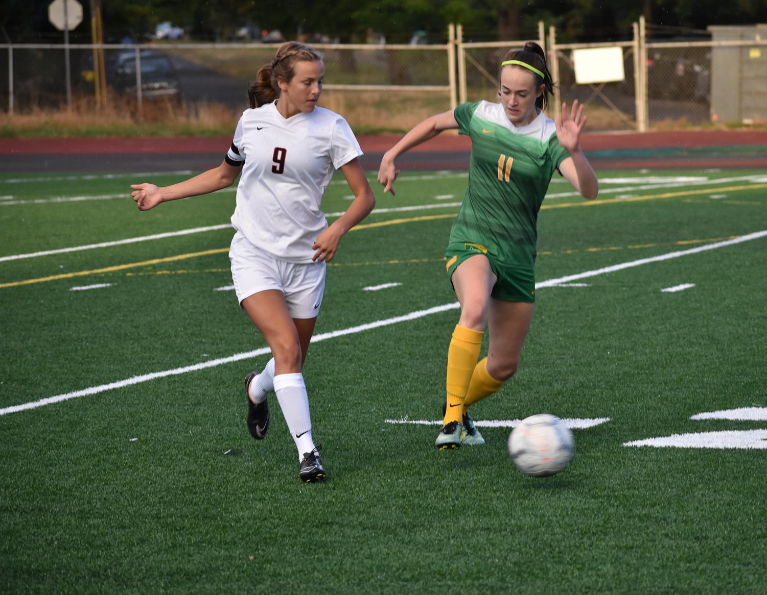 Grace Buchanan, junior, dribbles past defender Katrianne Sinn of Silverton. The Warriors defeated the Foxes 3-0 on Sept. 11 to improve their record to 3-1.
