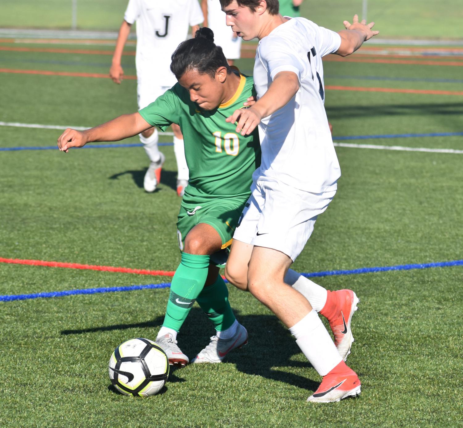 Senior Mario Lemus beats a Jesuit defender in the Warriors' opening varsity soccer game on Aug. 27. Cleveland lost 4-1.
