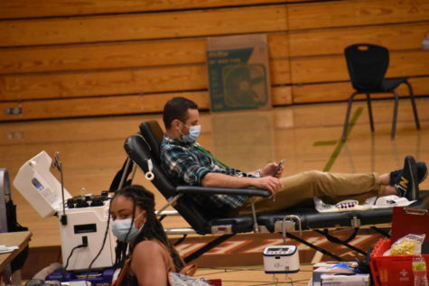 English teacher Eric Mirsepassi checks his phone after donating his blood.