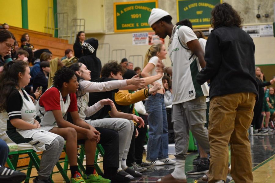The team and coaches offer support to the players after they come off the court.