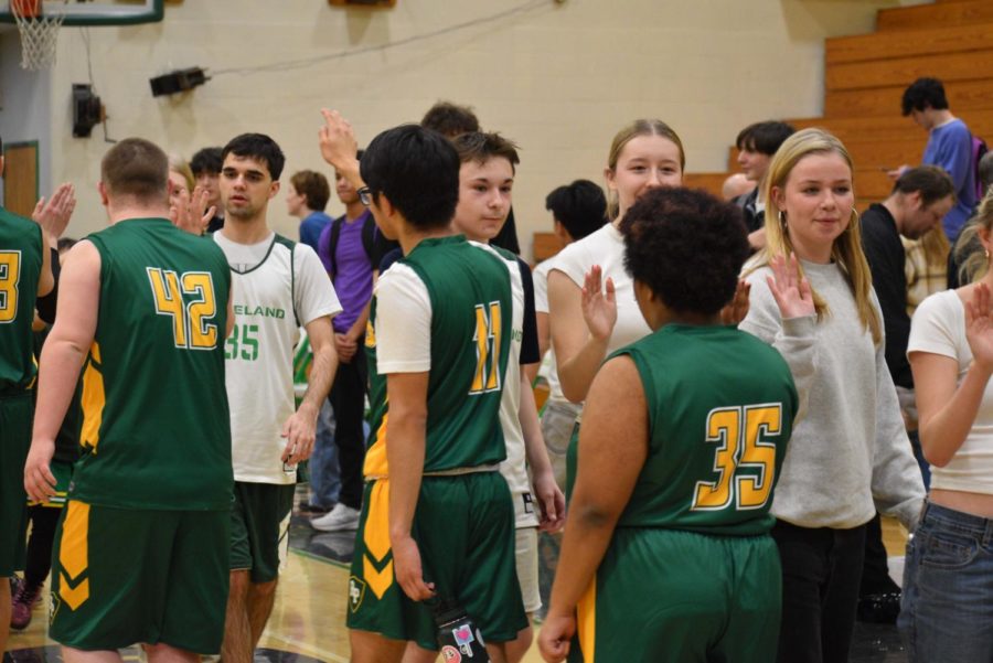 Charlie Delaney, William Bradford, Amalia Galm, and Gillian Taylor high-fiving Rex Putnam after the first game of the season.