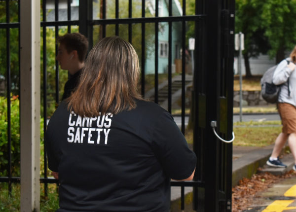 Campus safety checks students ID cards at the gate by the gym.