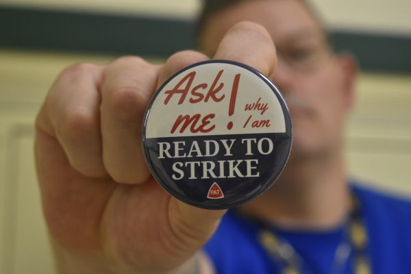 History teacher Nathan Pier holds up his PAT button. The Portland Association of Teachers voted to strike and unless the district and PAT come to an agreement, the PAT could walk off the job as soon as Nov. 1.