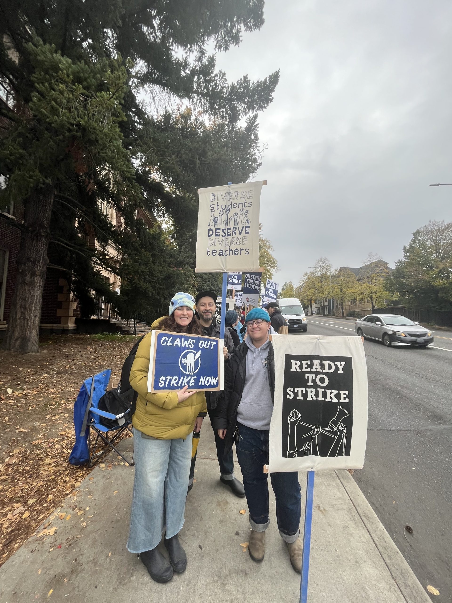 Picketing: Cleveland High School teachers, Ms. Muhs, Mr. Ereckson, and Mr. Shalman holding signs on the side of Powell Boulevard next to Cleveland.