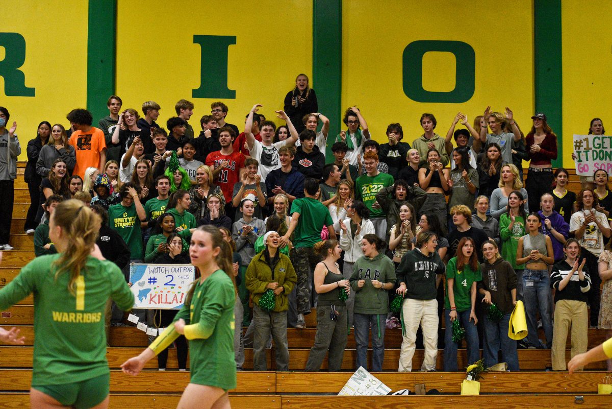 The crowd pumps up the volleyball team during a fall match.