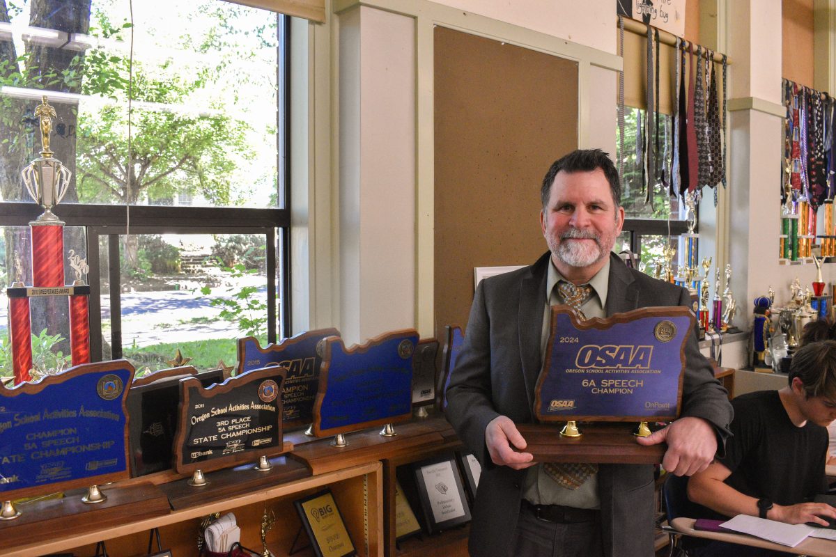 Mr. Gonzales holds the latest OSAA State Championship trophy.