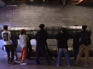 Baseball players work together to unload and set up mats of turf in the new facility. Natalie Benn photo.