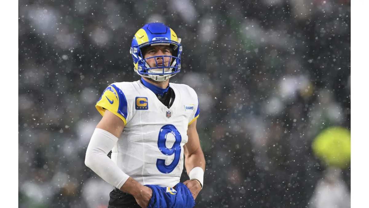 Rams quarterback Matthew Stafford looks on between plays as snow falls.